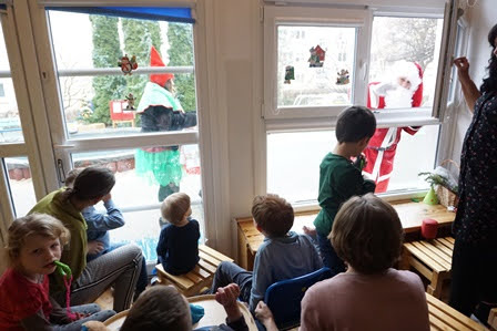 Święty Mikołaj wita dzieci przez okno
