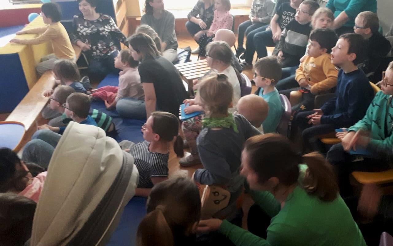 Dzieci siedzą i oglądają teatrzyk