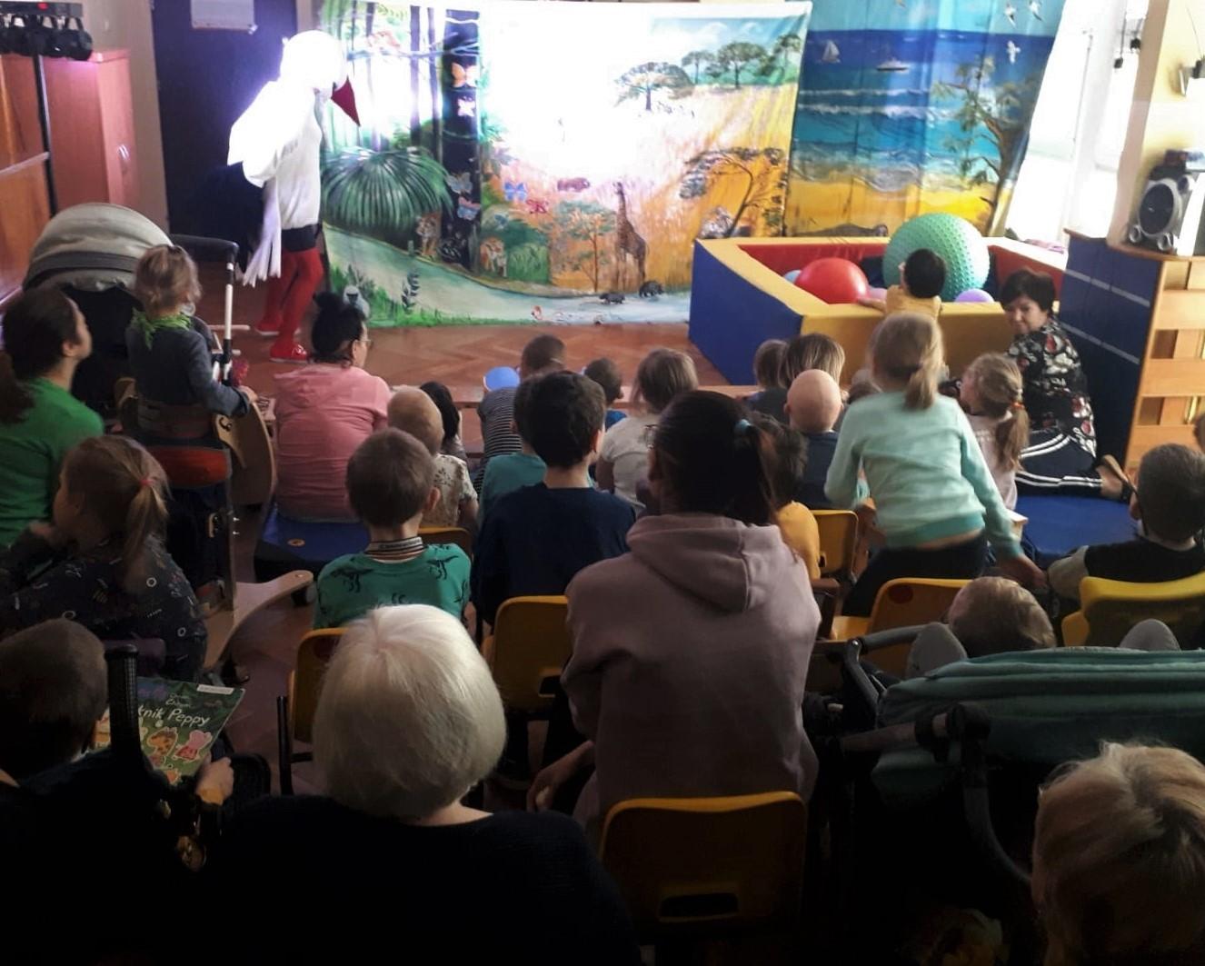 Dzieci oglądają przedstawienie teatralne z bocianem