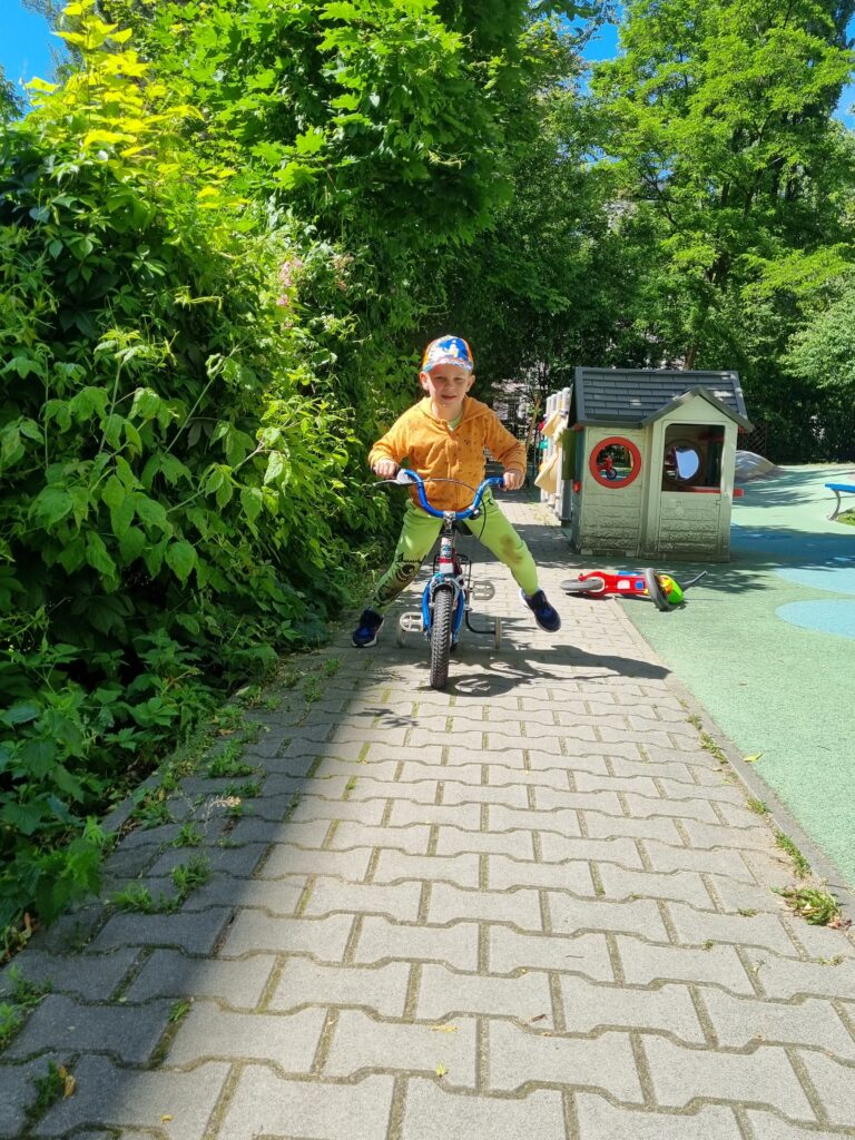 Chłopiec jedzie na rowerku.