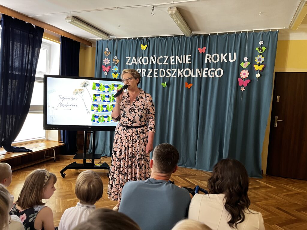 Dyrektor przemawia do zebranych na sali rodziców i dzieci.