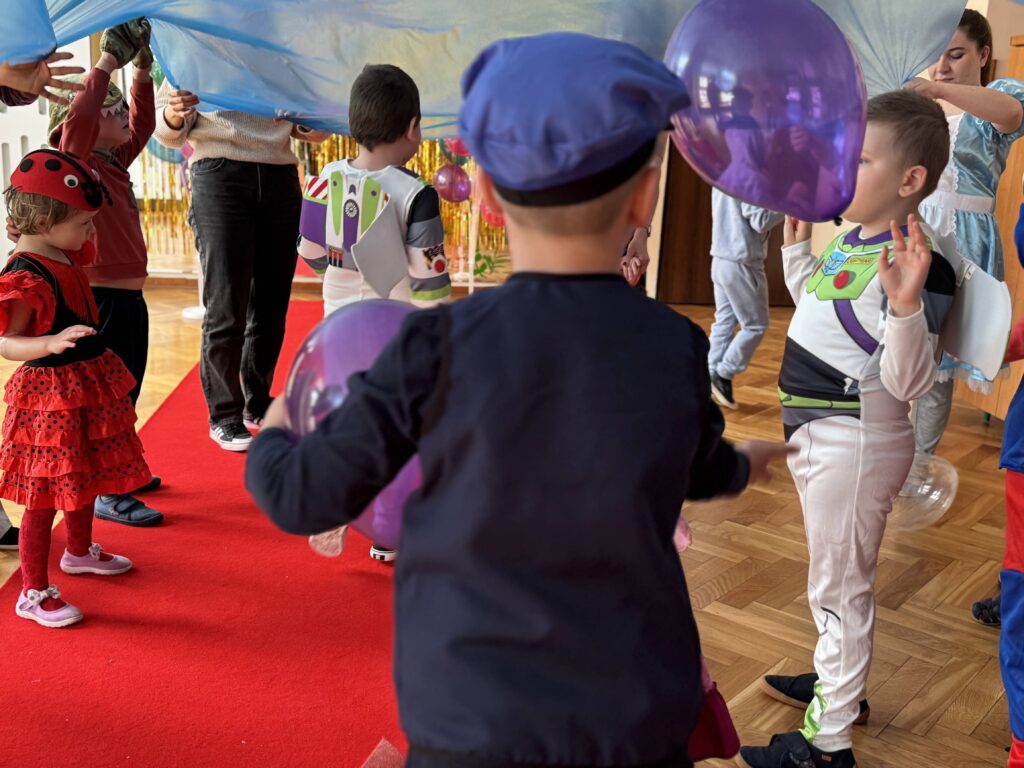 Dzieci bawią się pod niebieską folią